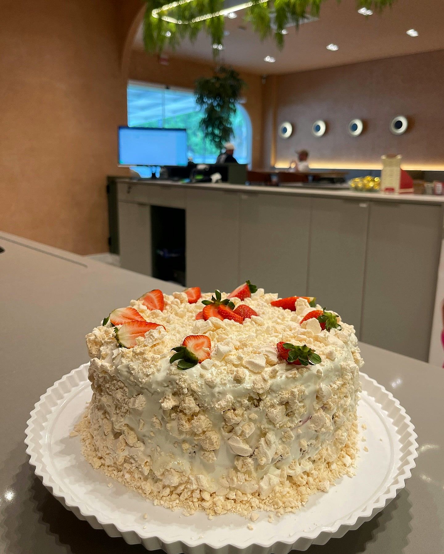 Bolo coberto de suspiro e morangos.