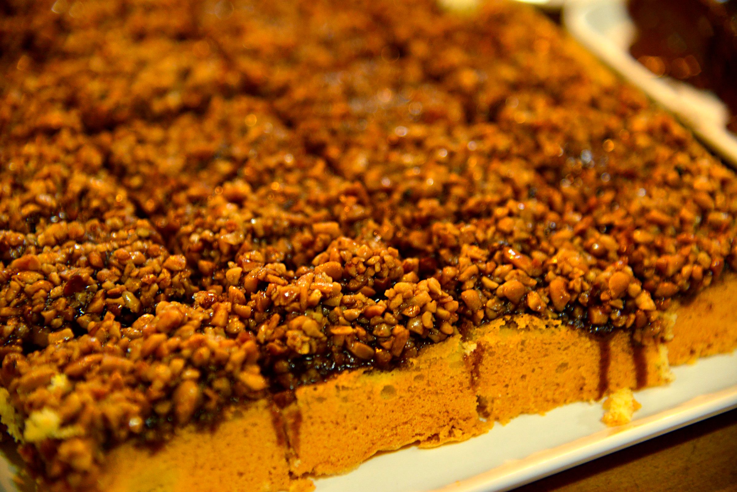 Cuca com farofa caramelizada cortada em quadrados.